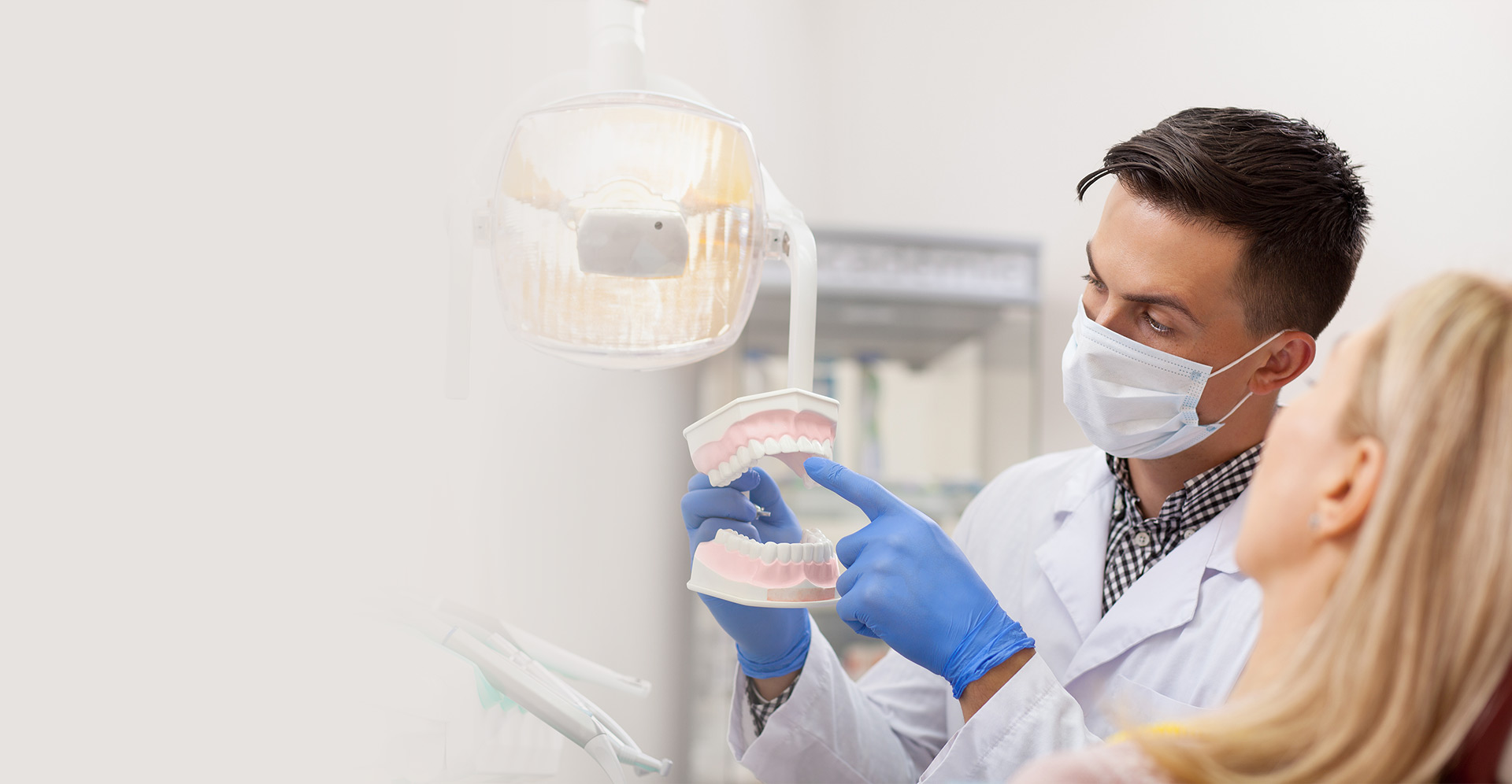 Oral surgeon pointing out teeth on artificial jaw